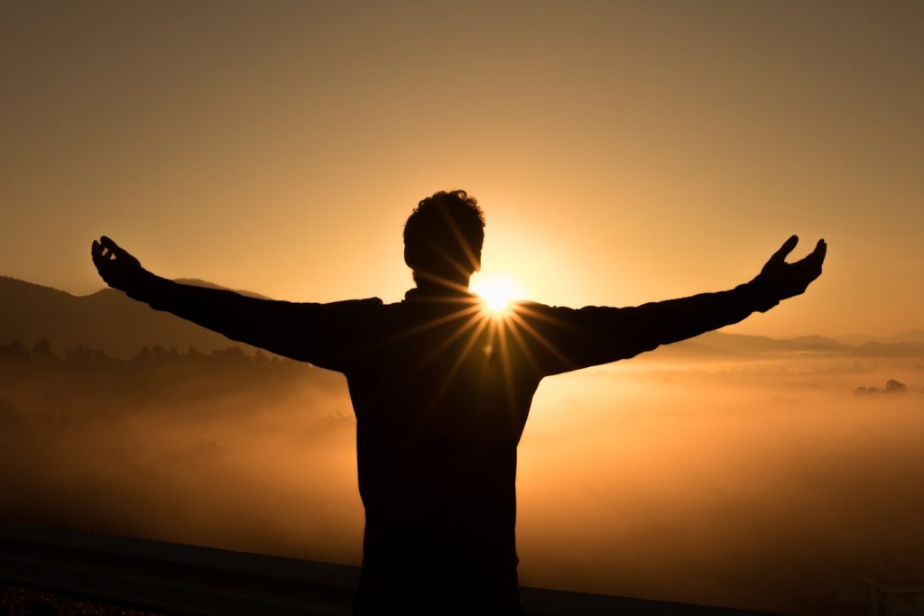 Person sitting on mountain cliff